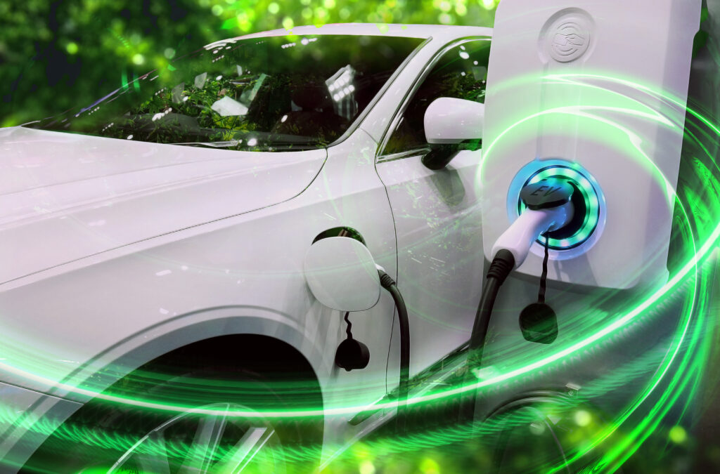 A white electric vehicle plugged in to a charger with green light surrounding it.