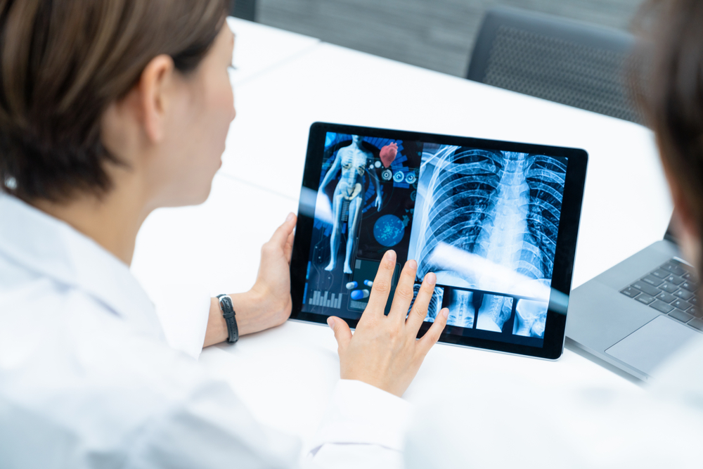 Surgeons viewing high-quality images of a skeleton on a tablet due to optical WDM.